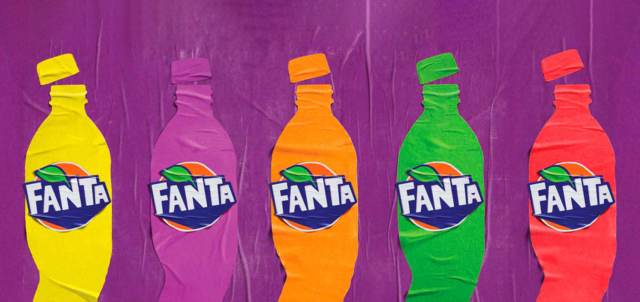 Cinco siluetas recortadas de papel de botellas de Fanta siendo destapadas sobre un fondo violeta. Cada silueta es de un color distinto representando los distintos sabores y tienen el logo de Fanta pegado en el centro