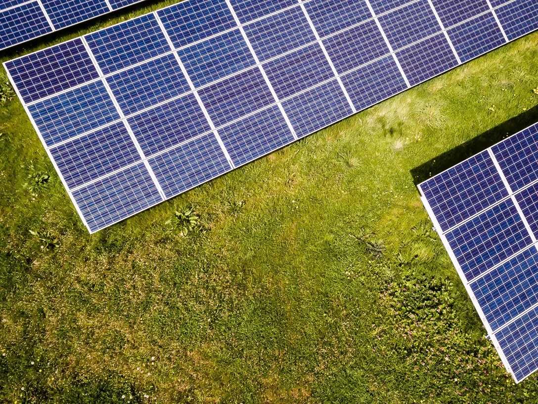منظر علوي لألواح الخلايا الشمسية في حقل أخضر