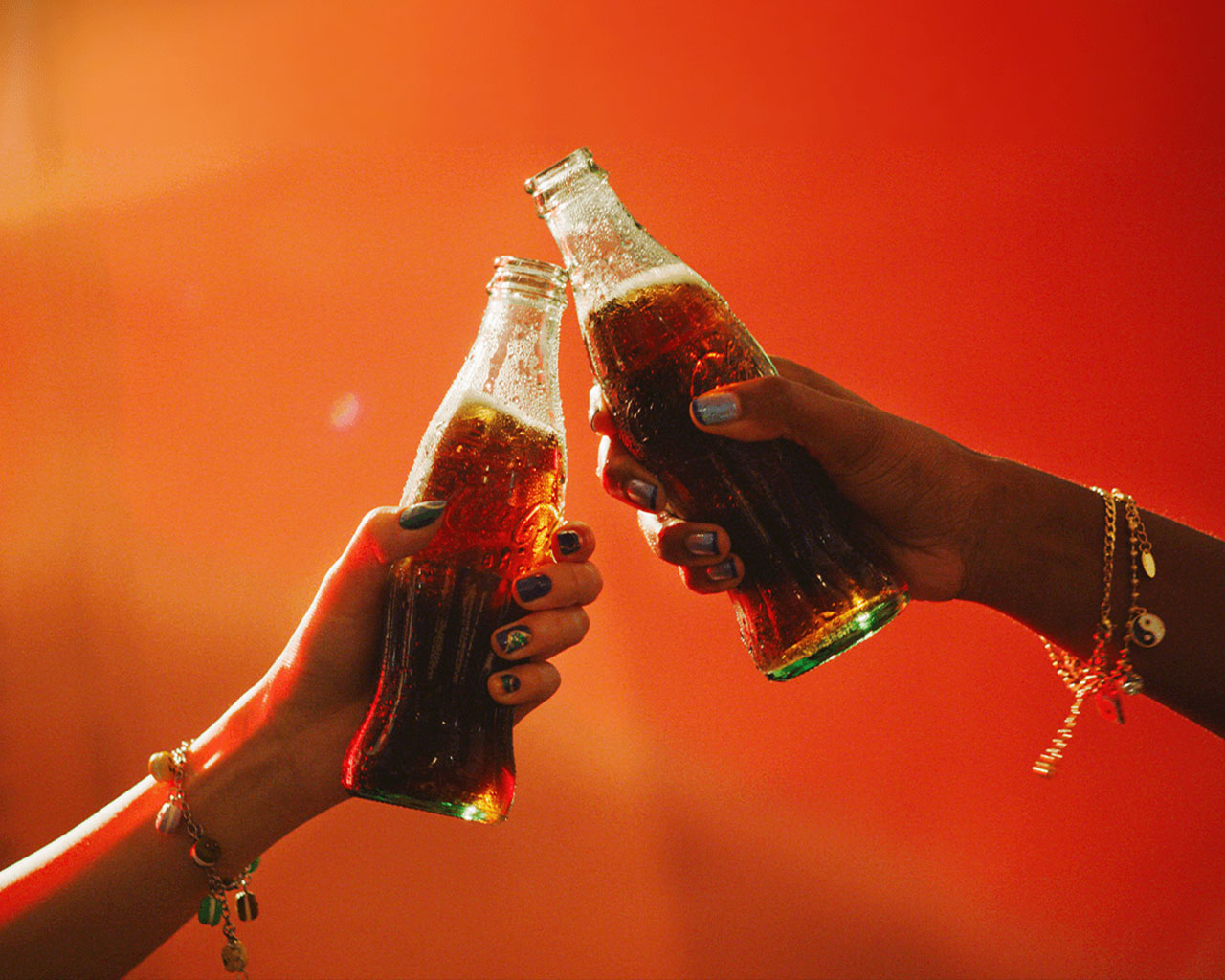 コカ・コーラで上向きに乾杯する両手