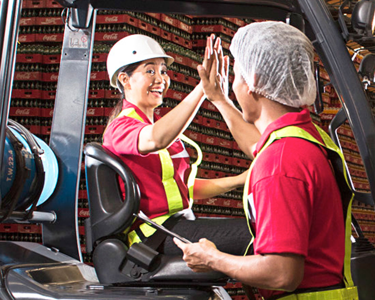 Two employees doing a high five inside a distribution center