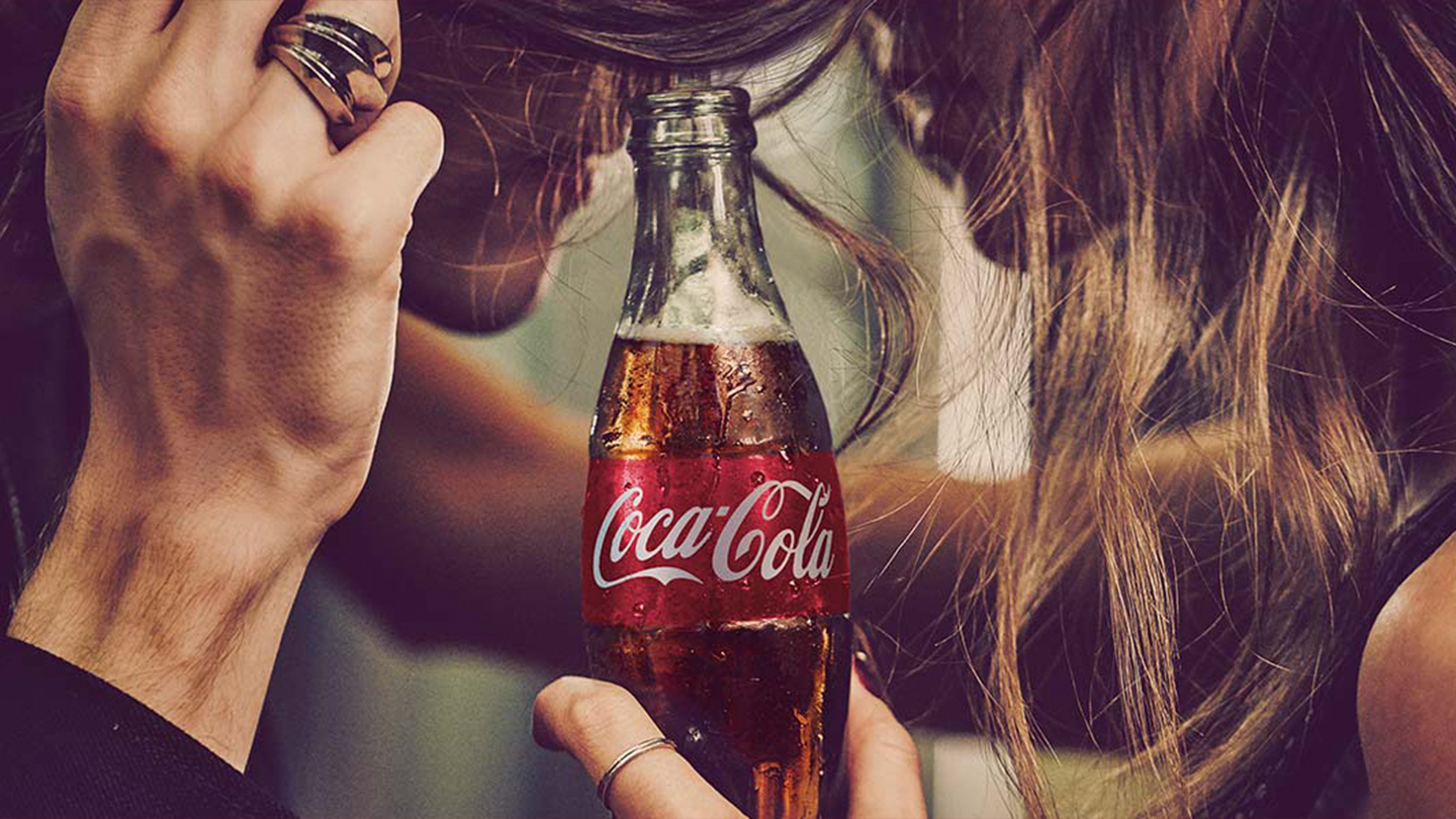 Młodzi ludzie z butelką Coca‑Cola