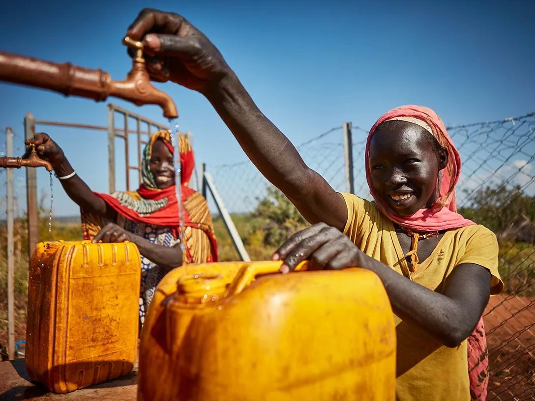 Mulheres enchem recipientes com água no distrito de Bambasi, como parte da iniciativa The Replenish Africa Initiative (RAIN)