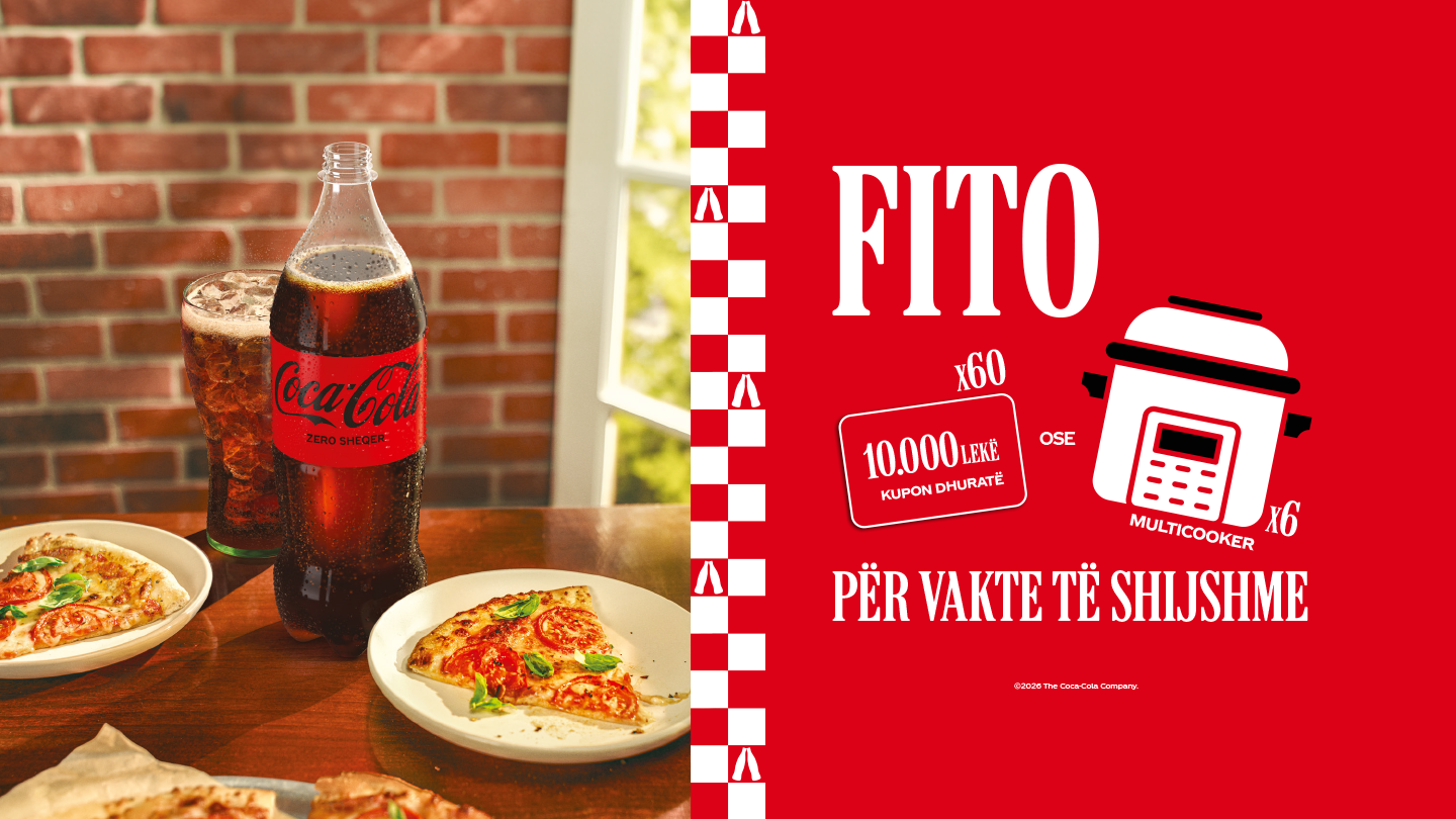 Vajza të ulura në tavolinë, duke ngrënë krahë pule dhe duke shijuar një Coca-Cola Zero.