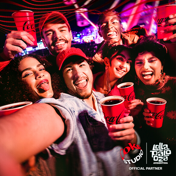 Grupo de amigos tomando Coca-Cola en vasos el Lollapalooza Argentina.