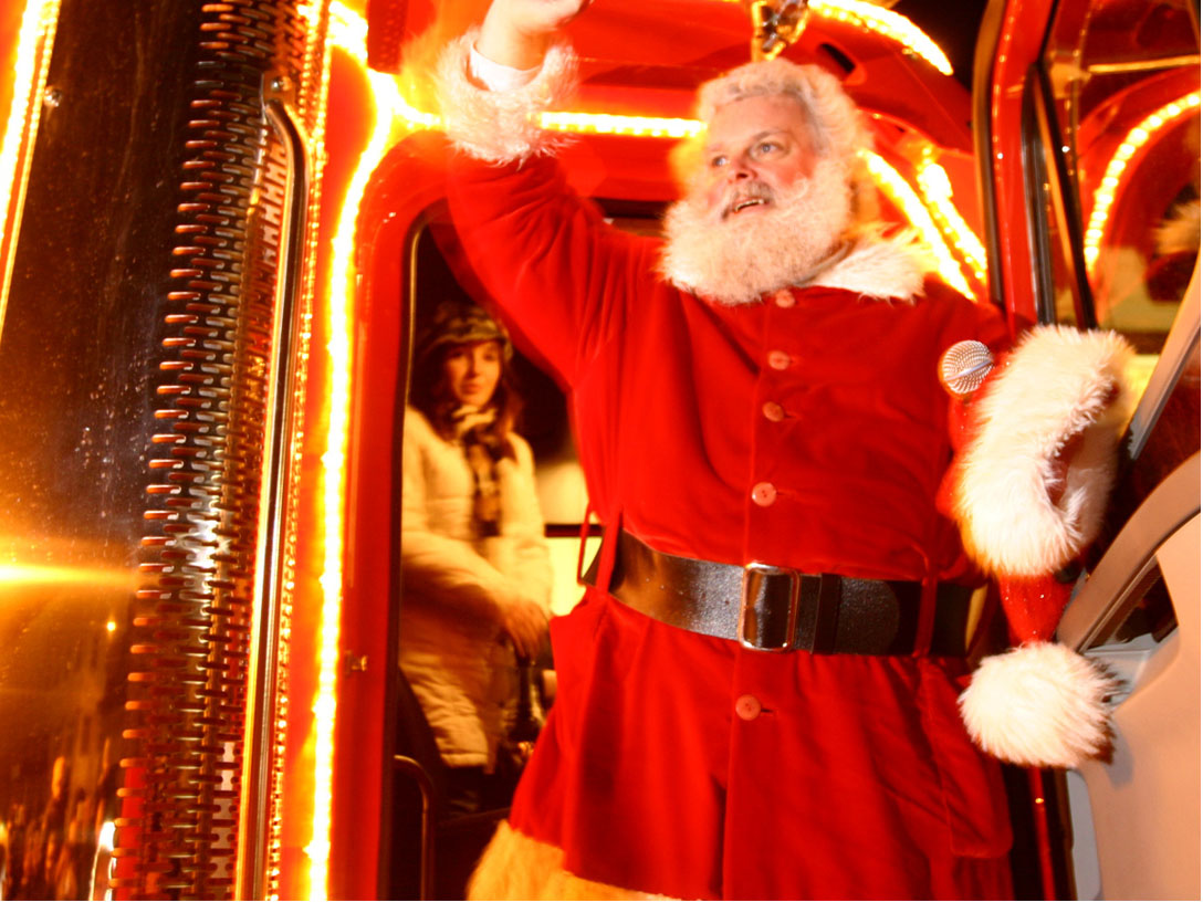 Coca-Cola Weihnachtsmann winkt aus Weihnachtstruck heraus