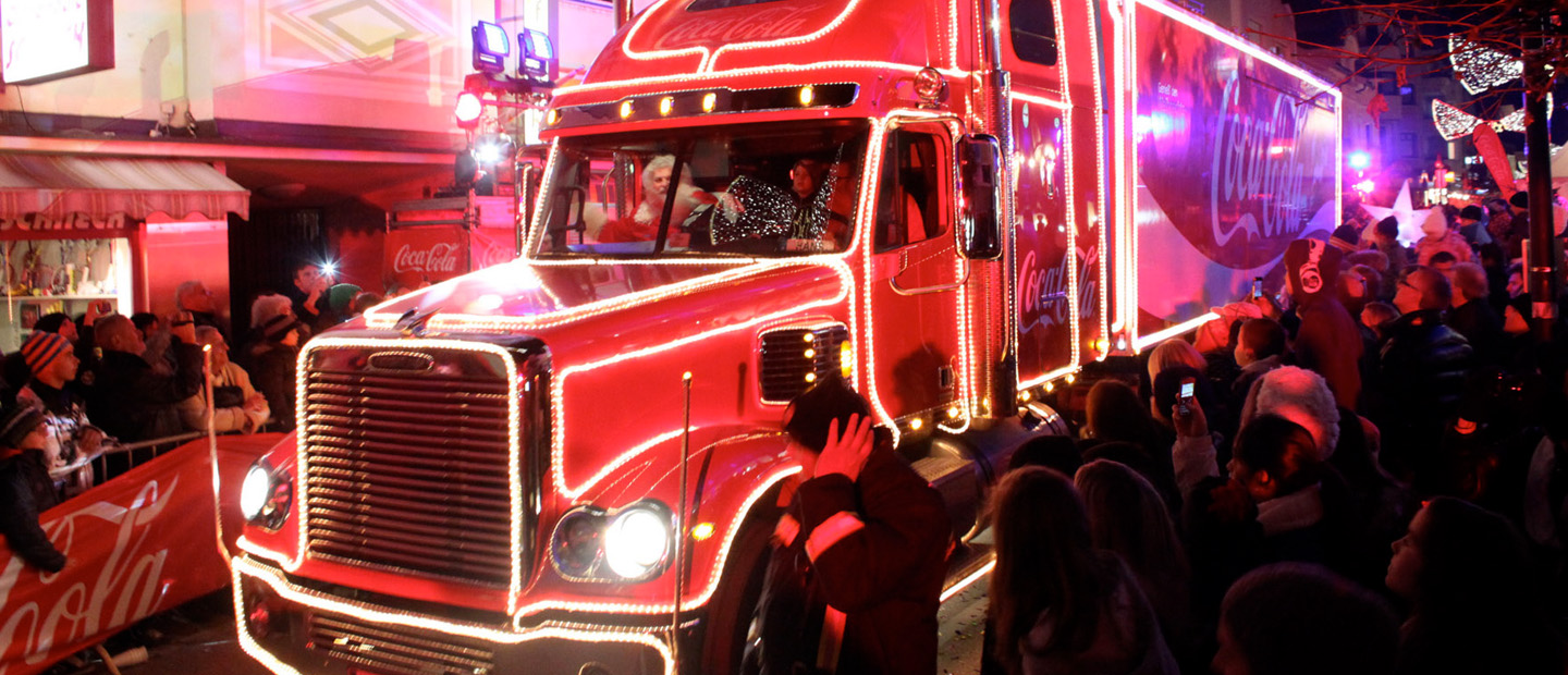 Der Coca-Cola Weihnachtstruck fährt durch eine Straße voller Fans.