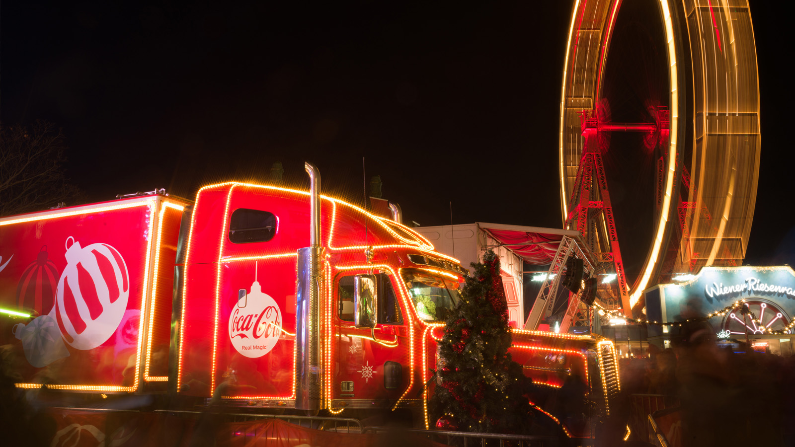 Coca-Cola Weihnachtstruck, leuchtend rot, im Wiener Prater in der Dunkelheit