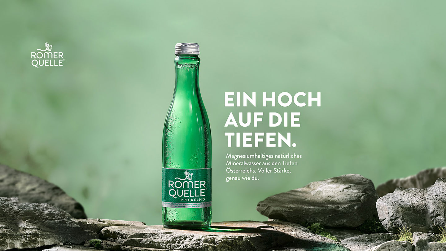 Banner mit einer Flasche Römerquelle und dem Text „Ein Hoch auf die Tiefen. Magnesiumhaltiges natürliches Mineralwasser aus den Tiefen Österreichs. Voller Stärke, genau wie du.“
