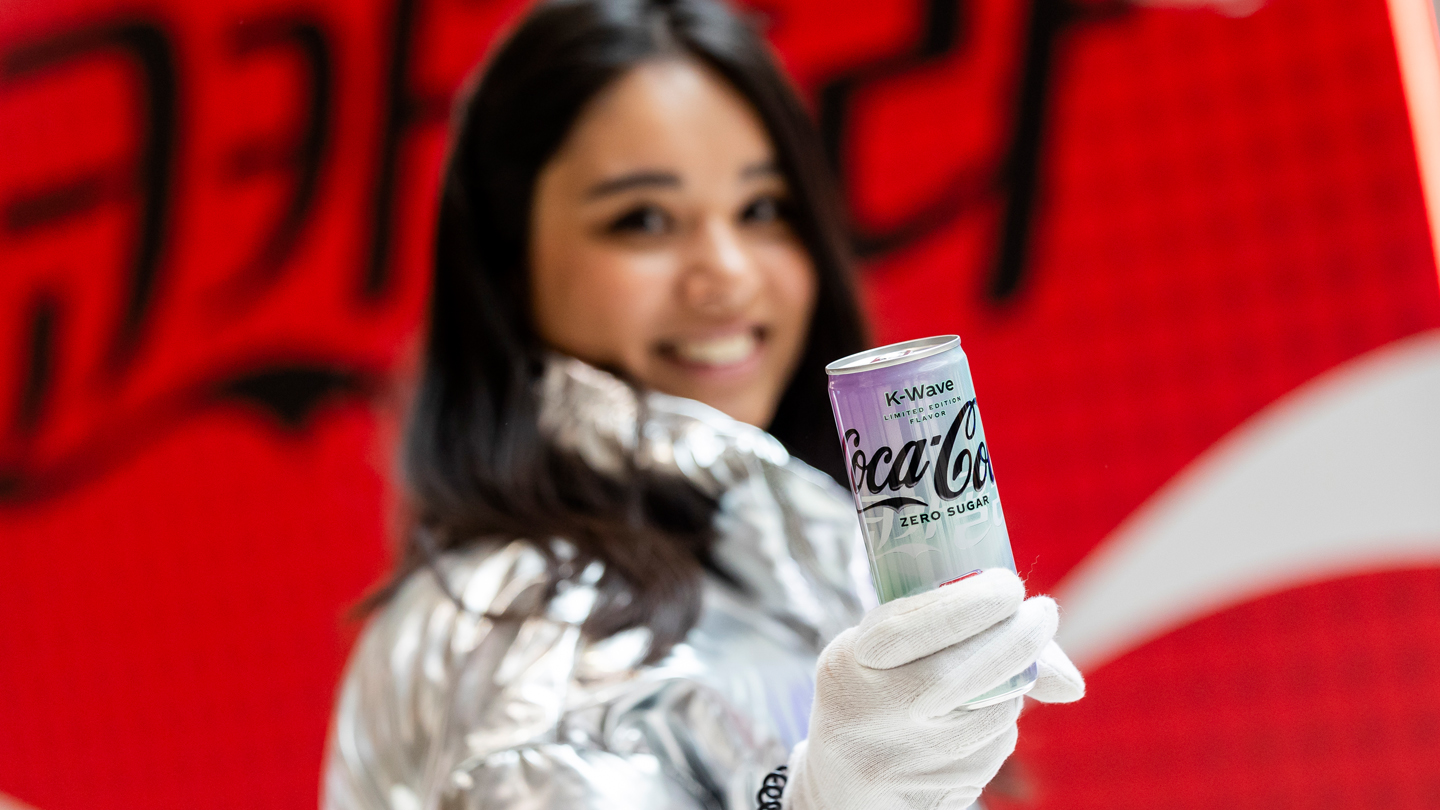 Frau mit Coca-Cola K-Wave Zero Sugar Dose in Hand