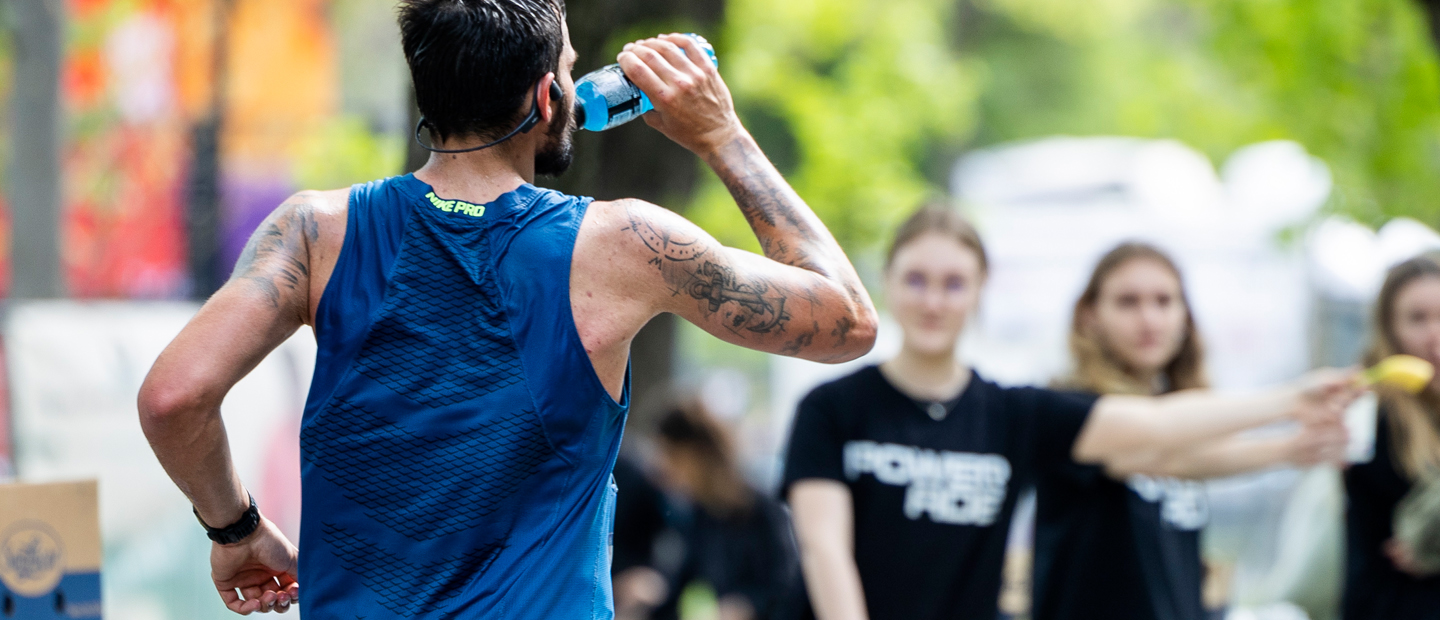 laufende Person, die von einer Powerade Flasche trinkt