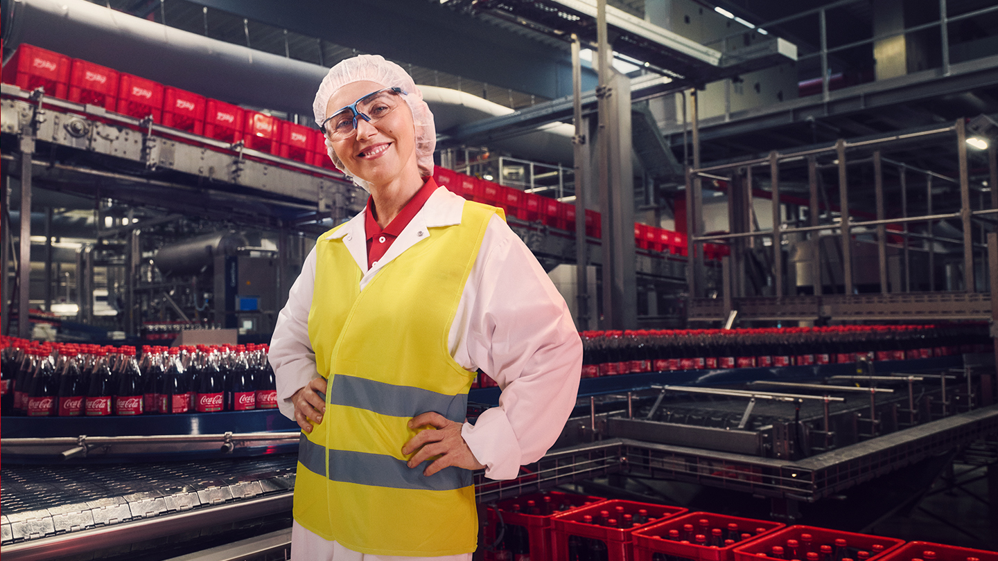 Daniela überwacht Produktion von Coca-Cola Flaschen an der Produktionsstraße
