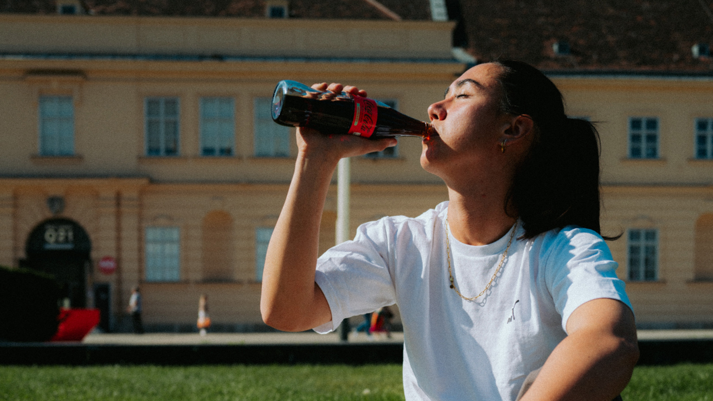 Portrait von Teamtorhüterin Manuela Zinsberger während sie Coca-Cola trinkt