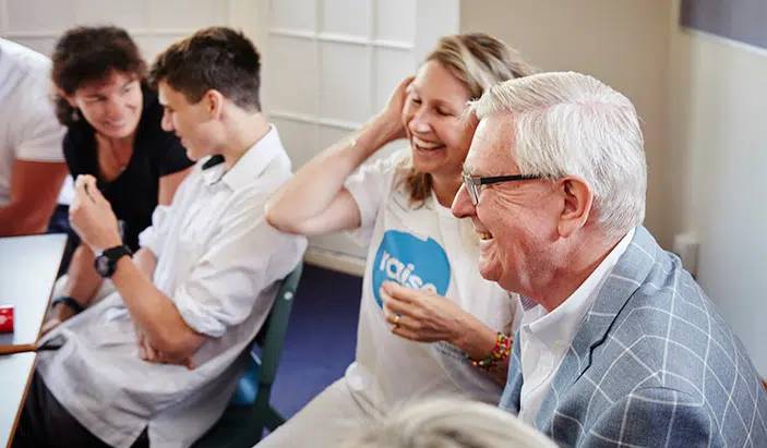 A group of people laughing in an interior space