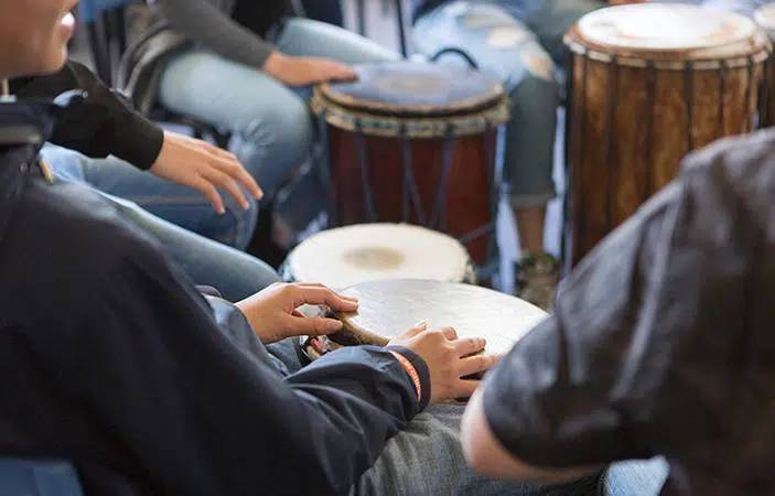 A group of people in a circle playing drums