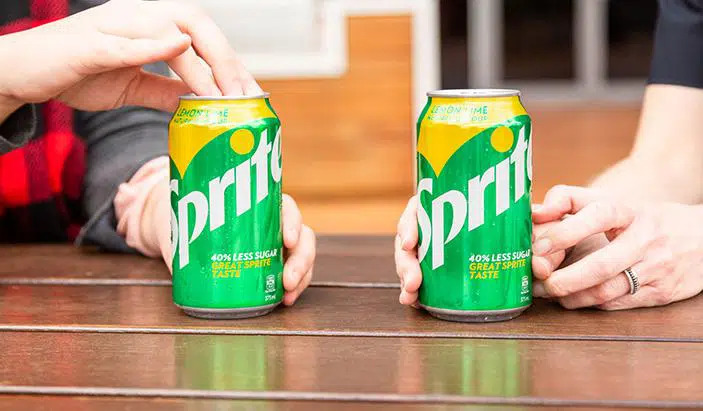 Detail of hands opening and holding Sprite cans