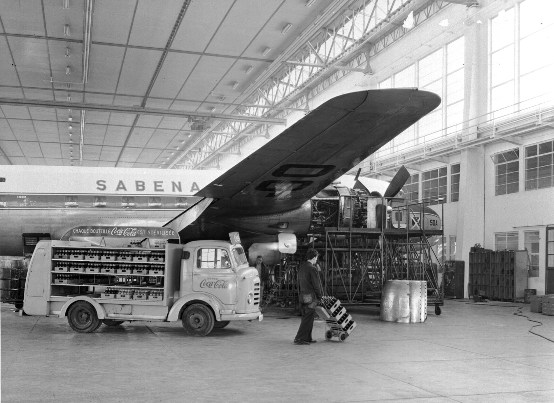 Voiture Coca-Cola à côté d'un avion Sabena