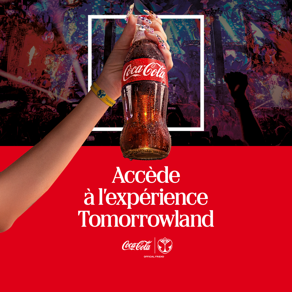 Une main portant un bracelet de festival lève une bouteille de Coca‑Cola devant une foule colorée de festival, avec un encadré blanc et un bandeau rouge affichant le message promotionnel.