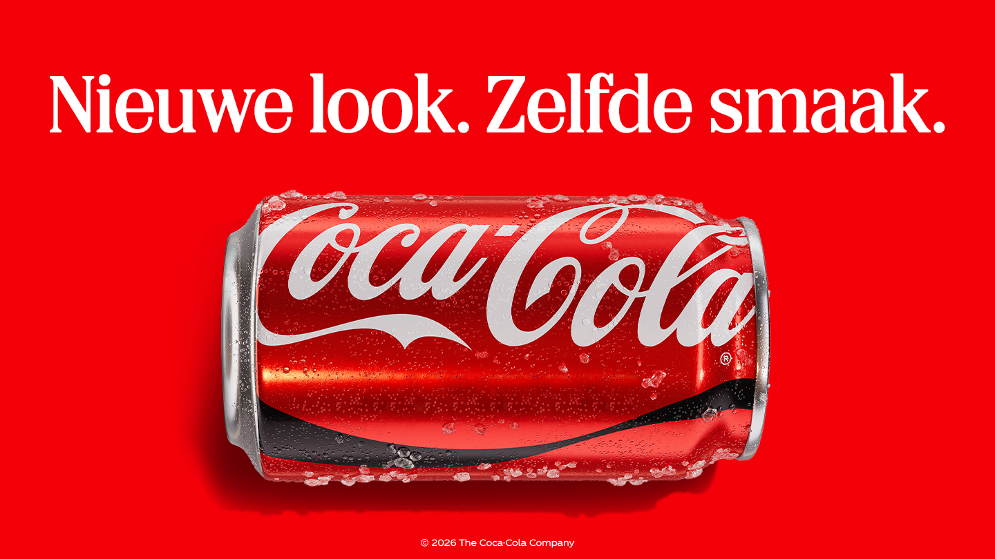 Rood Coca-Cola-blikje dat horizontaal ligt op een felrode achtergrond, bedekt met waterdruppels en ijs. Bovenaan staat in witte tekst: “Nieuwe look. Zelfde smaak.” Onderaan staat de vermelding: “© 2026 The Coca-Cola Company”.