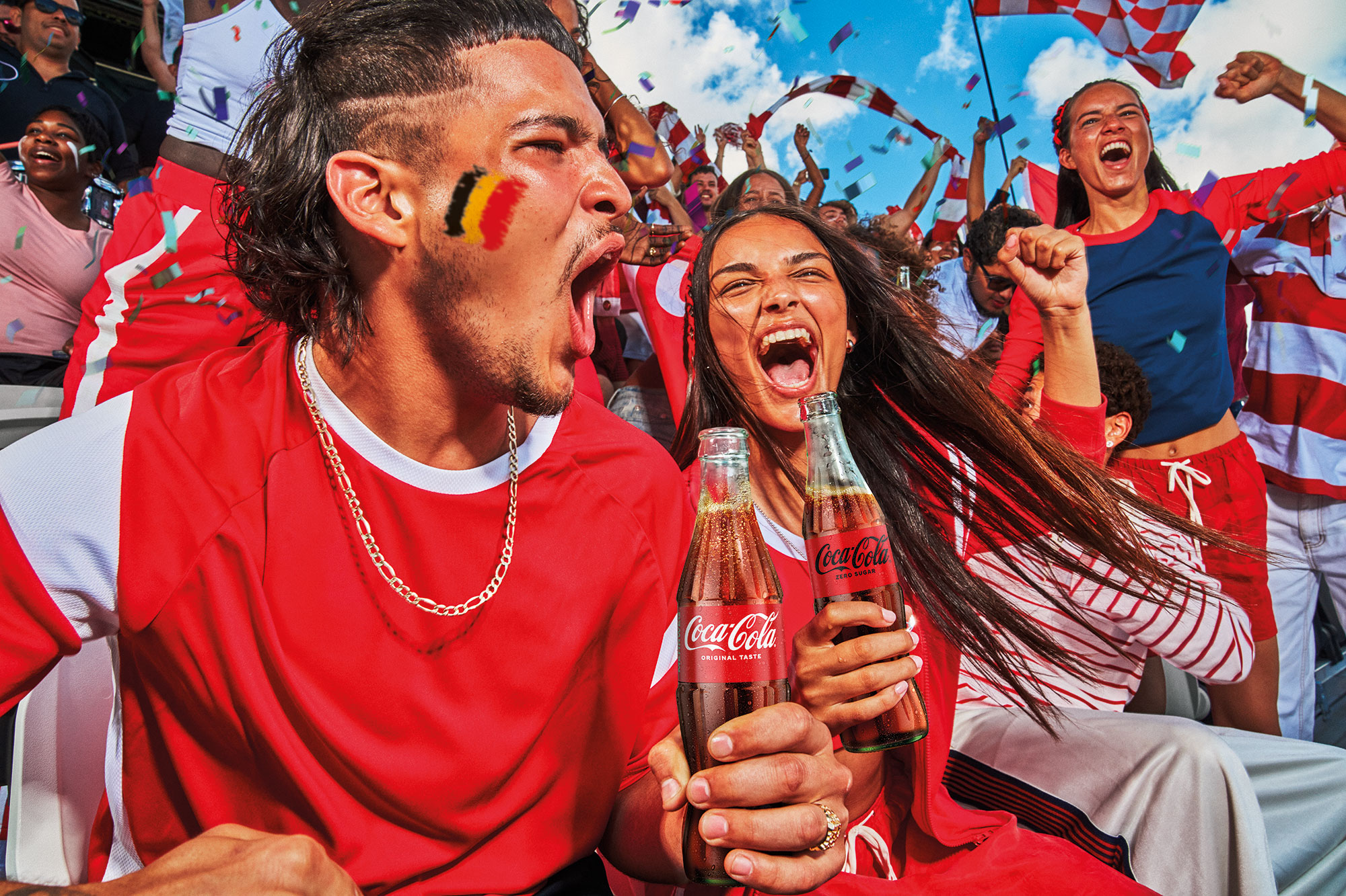 Uitgelaten fans in stadium houden Coca-Cola flesje vast