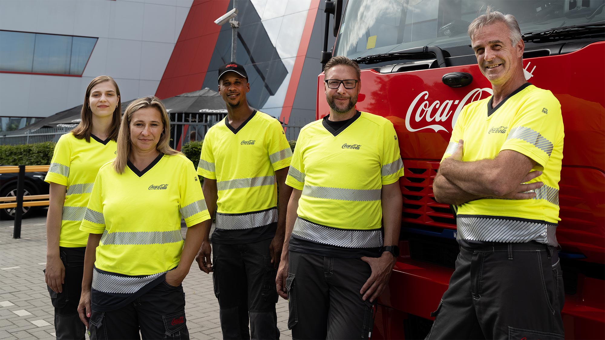 Des employés de Coca-Cola posent côte à côte