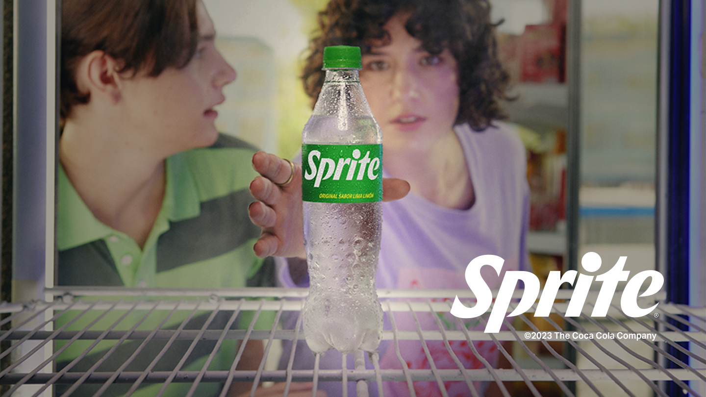 Dos jóvenes agarran una Sprite de una heladera