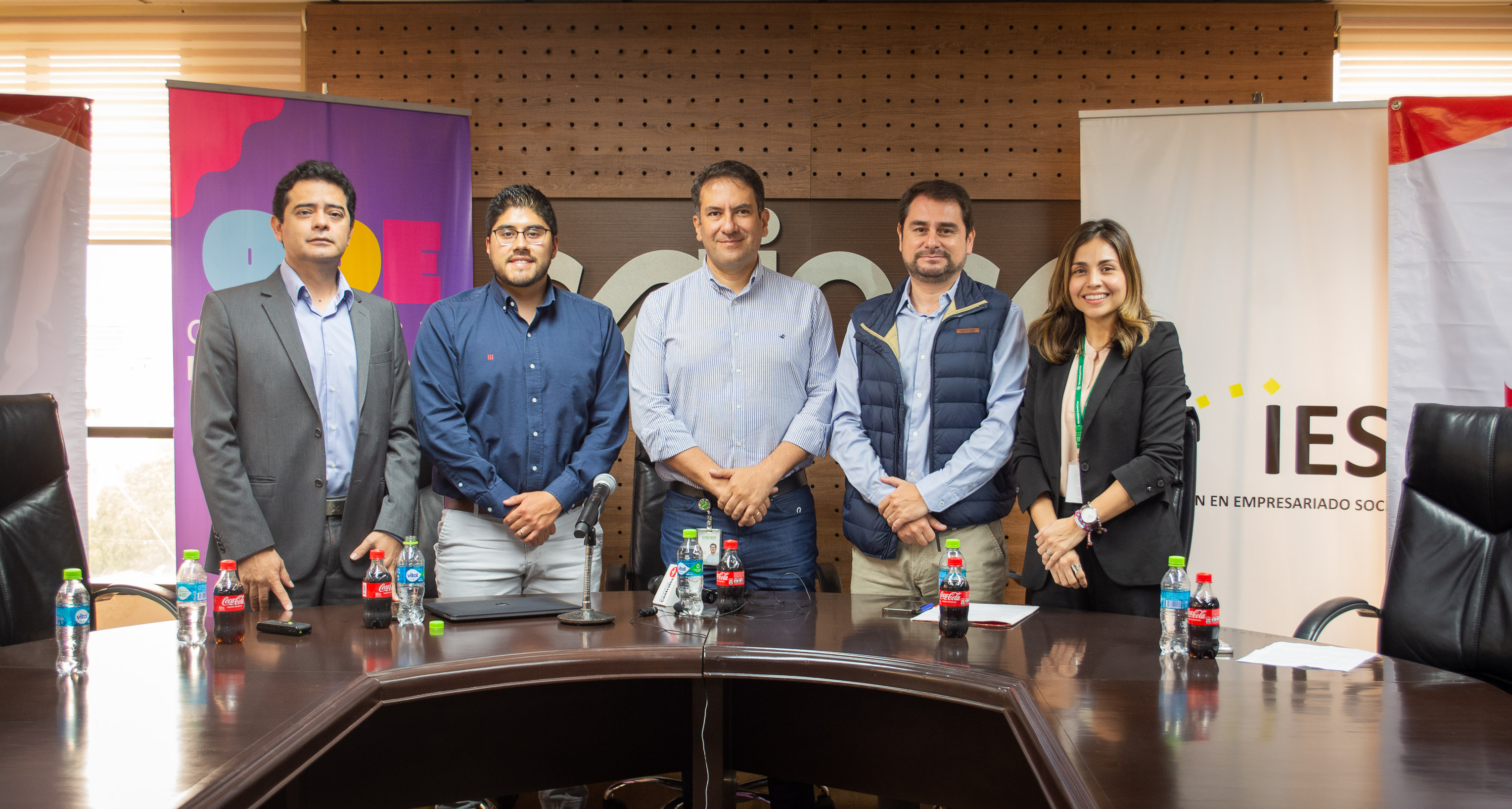 Cinco personas posan detrás de una mesa