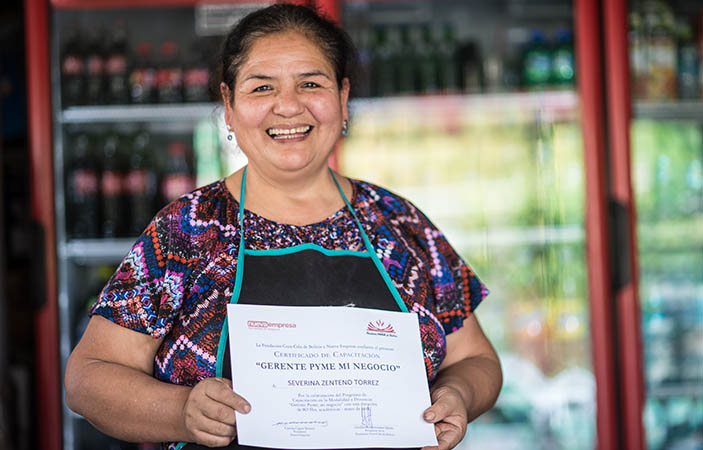 Mujer posa sonriente con un Certificado de Capacitación