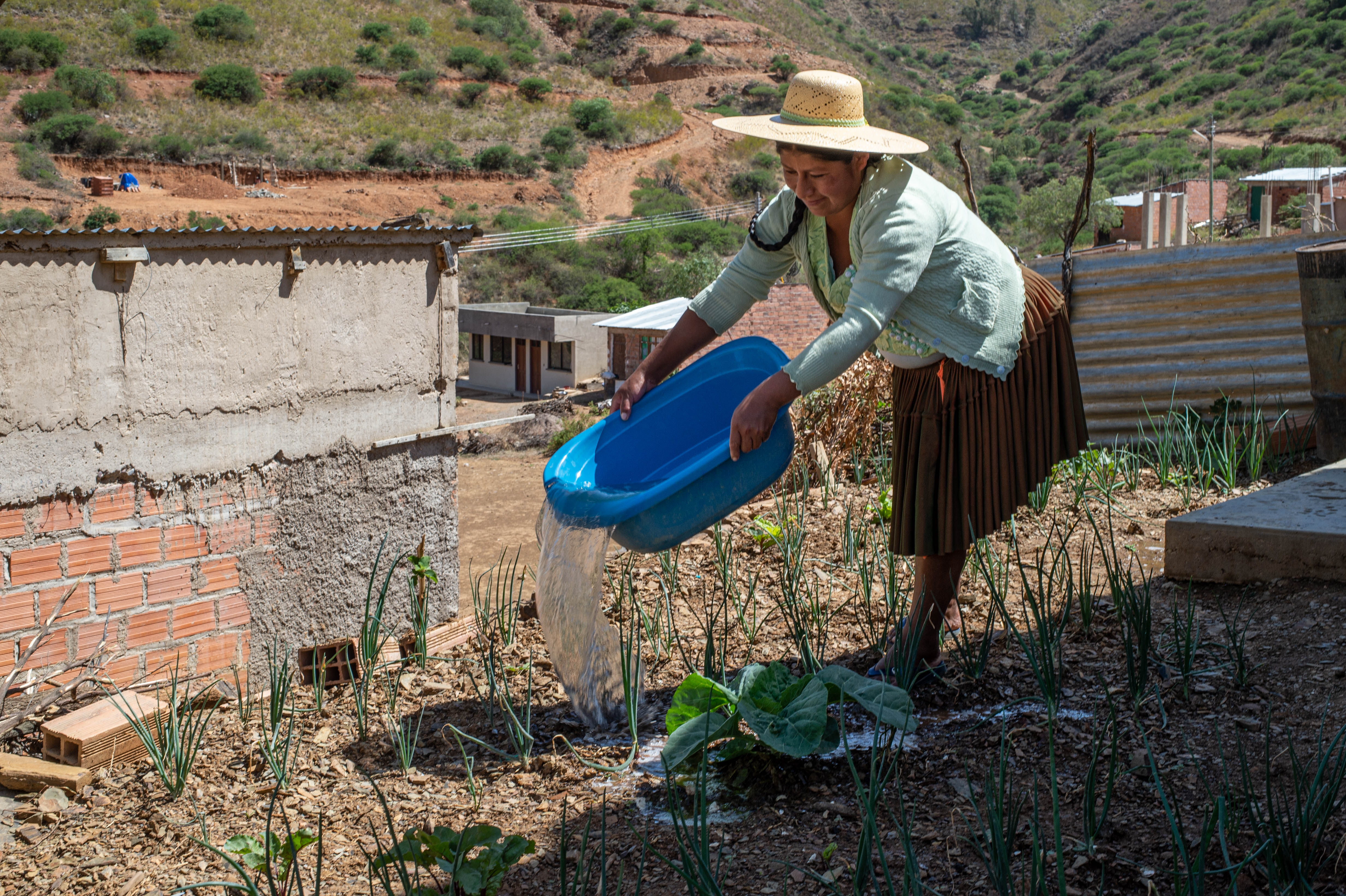 Una mujer riega las plantas de su jardín