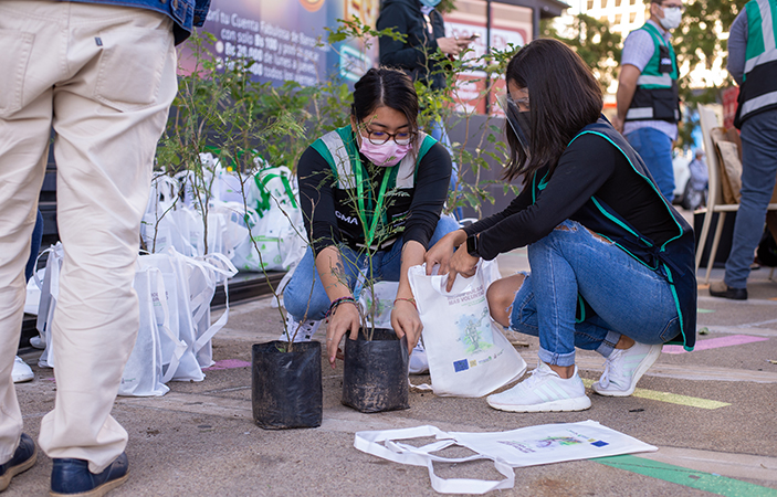 Dos mujeres preparan los kits que los asistentes reciben a cambio por sus reciclables