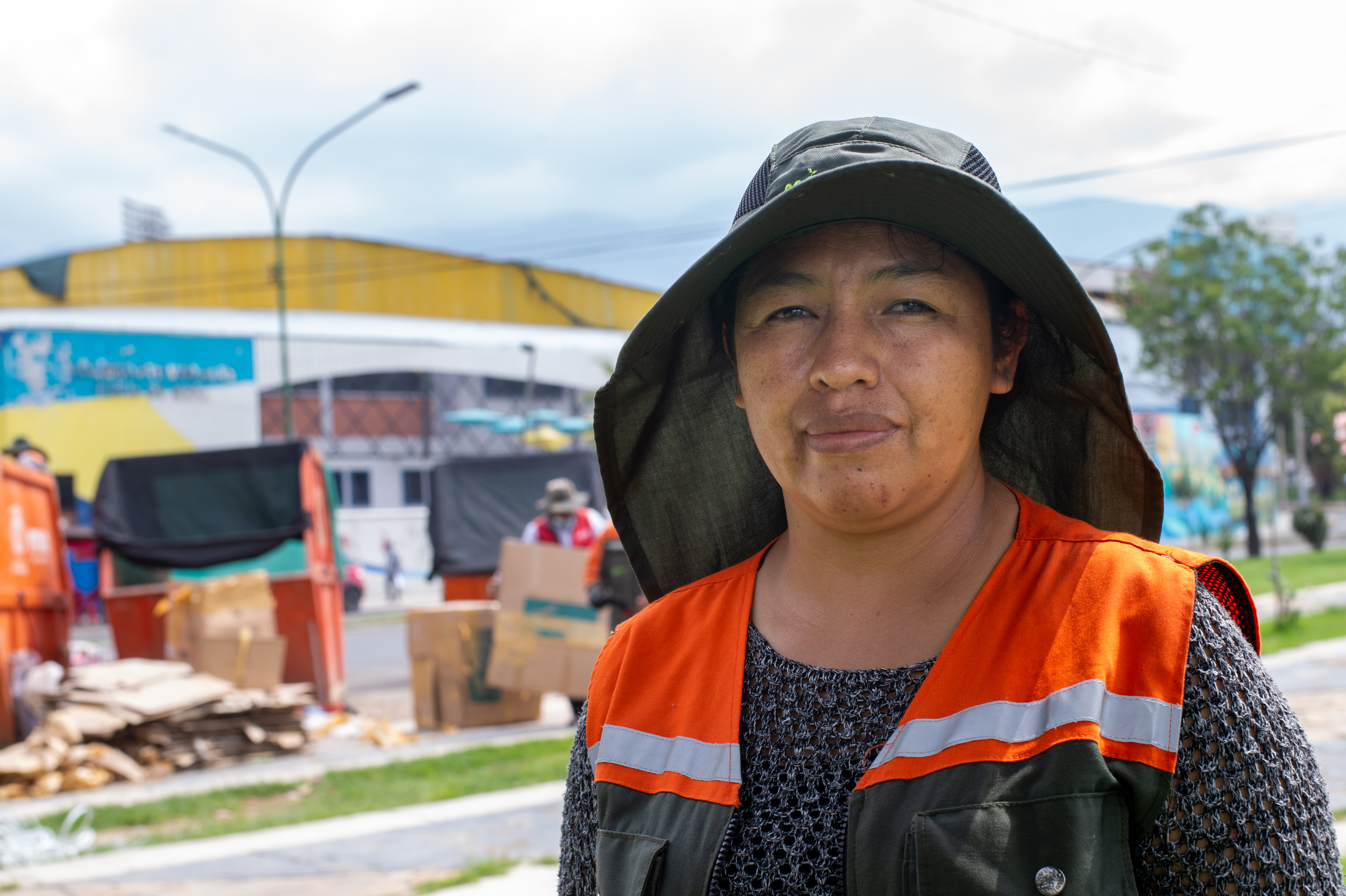 Recolectora en la calle con residuos de cartón de fondo