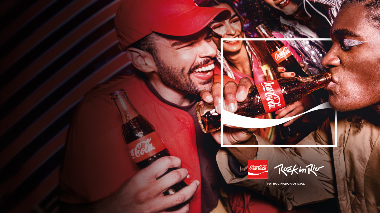 Grupo de amigos sorrindo e segurando copos de Coca-Cola.