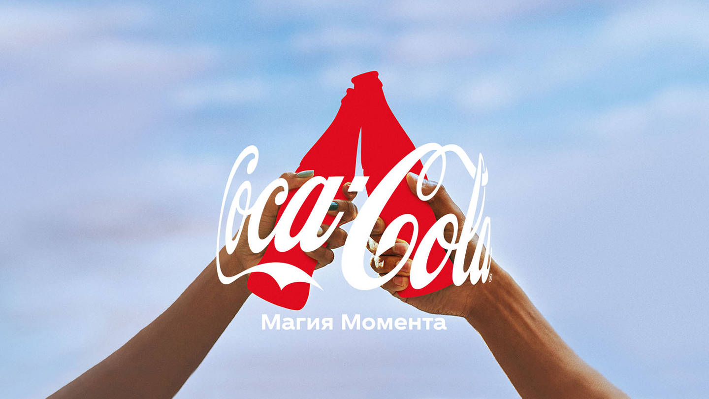 Две руки радостно поднимают бутылки Coca-Cola красного цвета