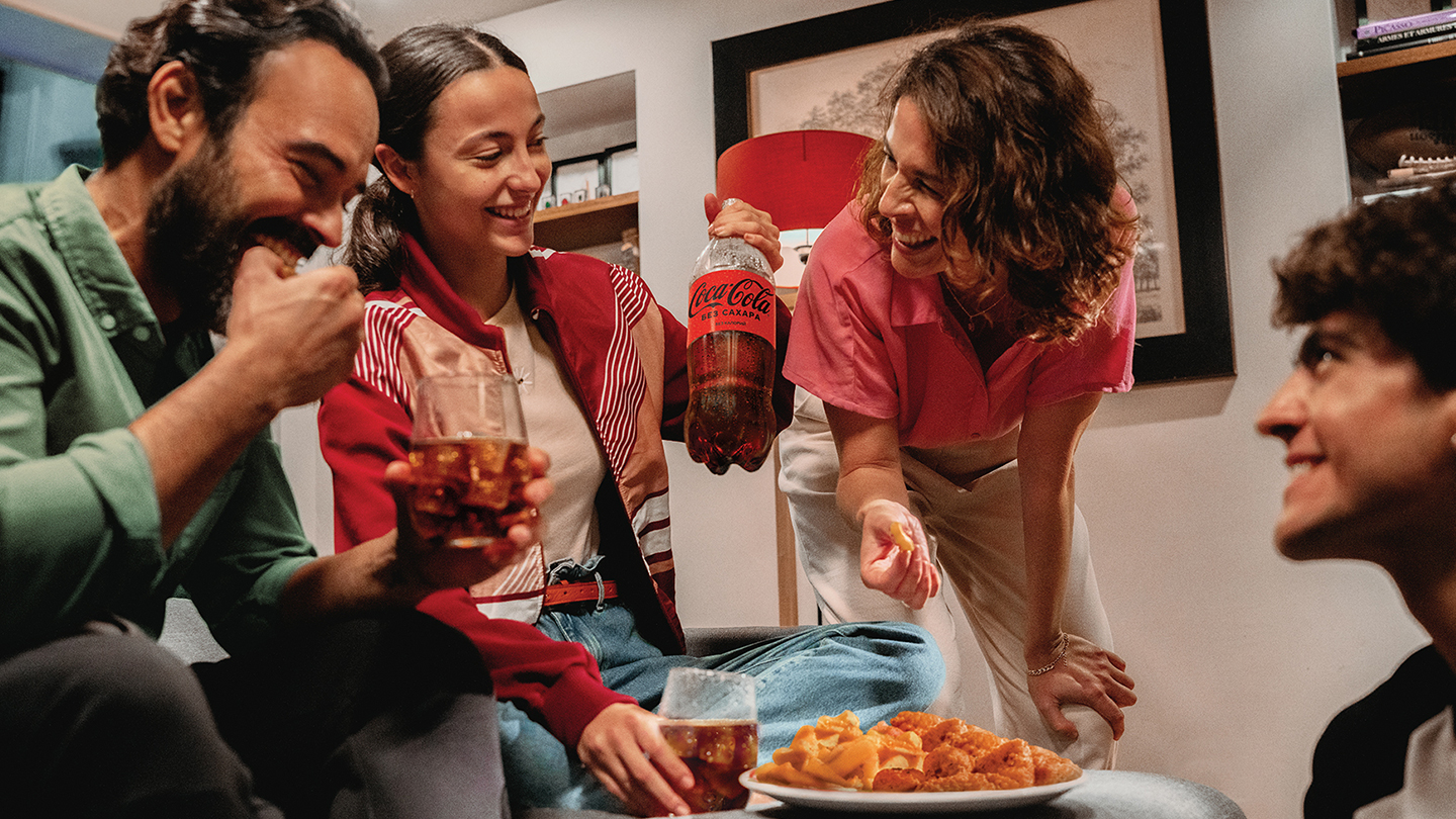 Группа людей наслаждается своей едой с Coca-Cola без сахара