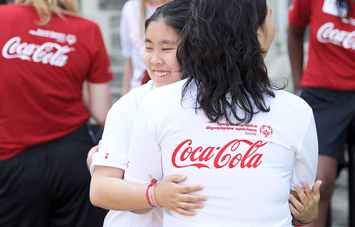 A Special Olympics athlete hugging a volunteer at an event