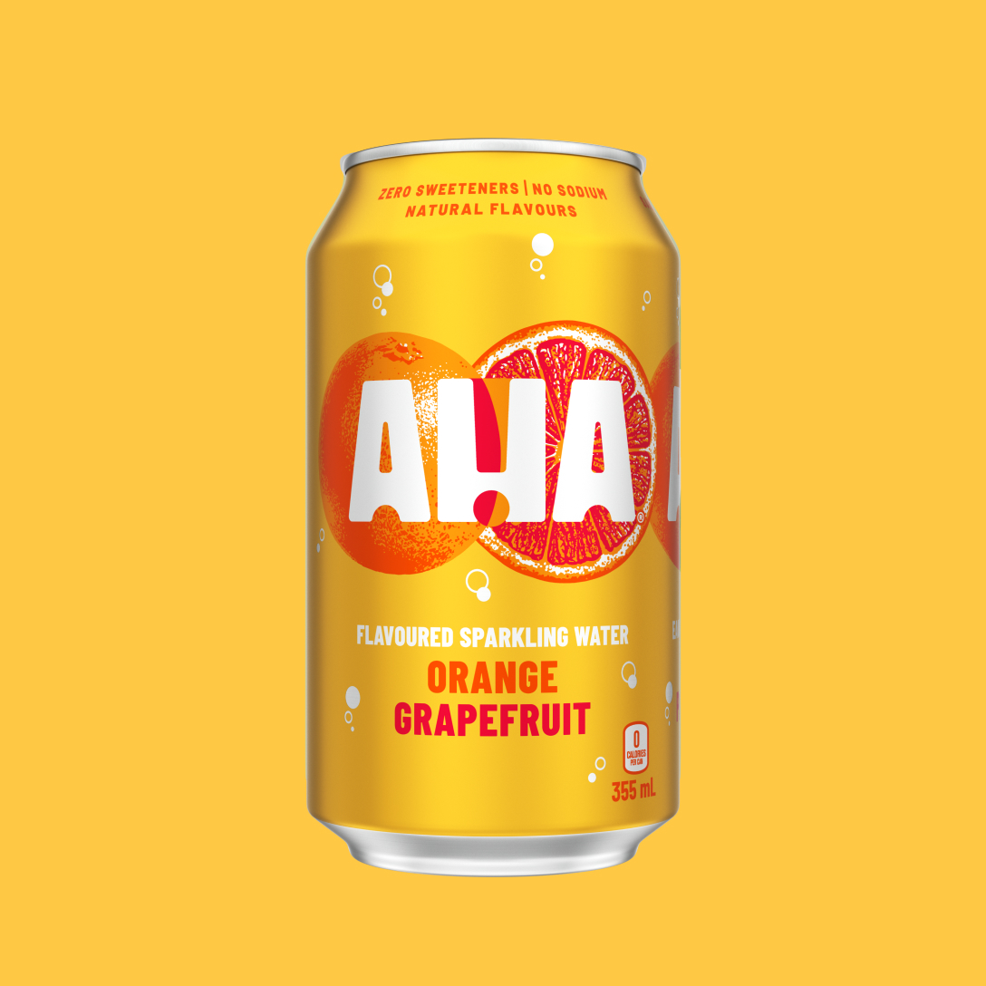 A golden-yellow 355 mL can of AHA Orange Grapefruit flavoured sparkling water, with an illustrated orange and grapefruit slice behind the white AHA logo. Text on the can reads "Zero sweeteners | No sodium | Natural flavours" and "0 calories per can," shown on a matching yellow background.
