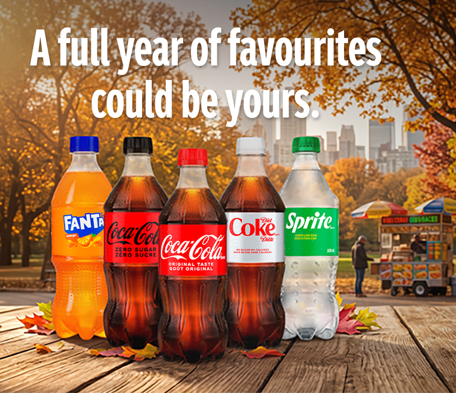Assorted Coca-Cola beverages on an autumn park table promoting a chance to win a full year of favourites.