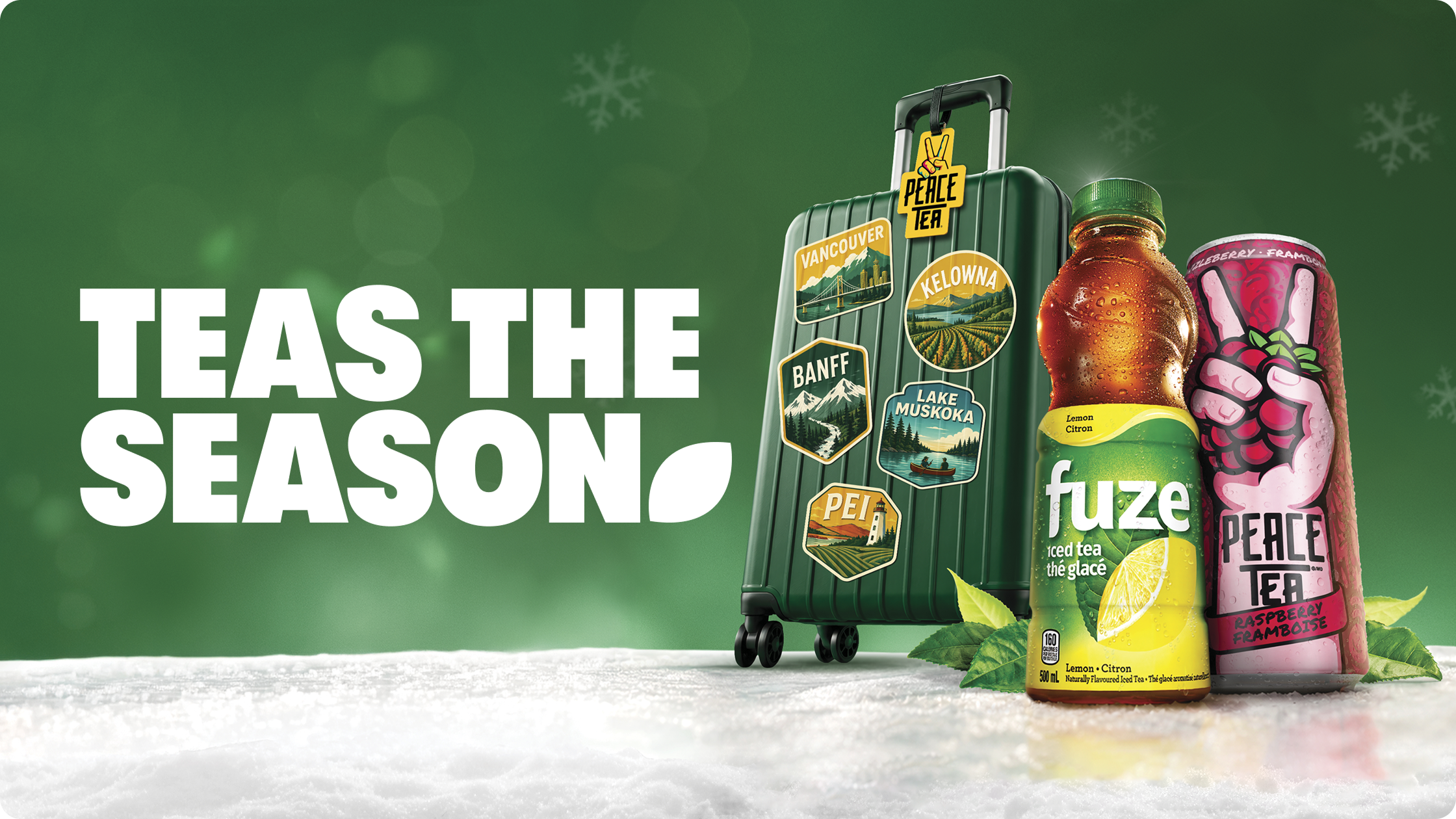 Fuze iced tea and Peace Tea beside a green travel suitcase in the snow, below the holiday promo text Teas The Season.