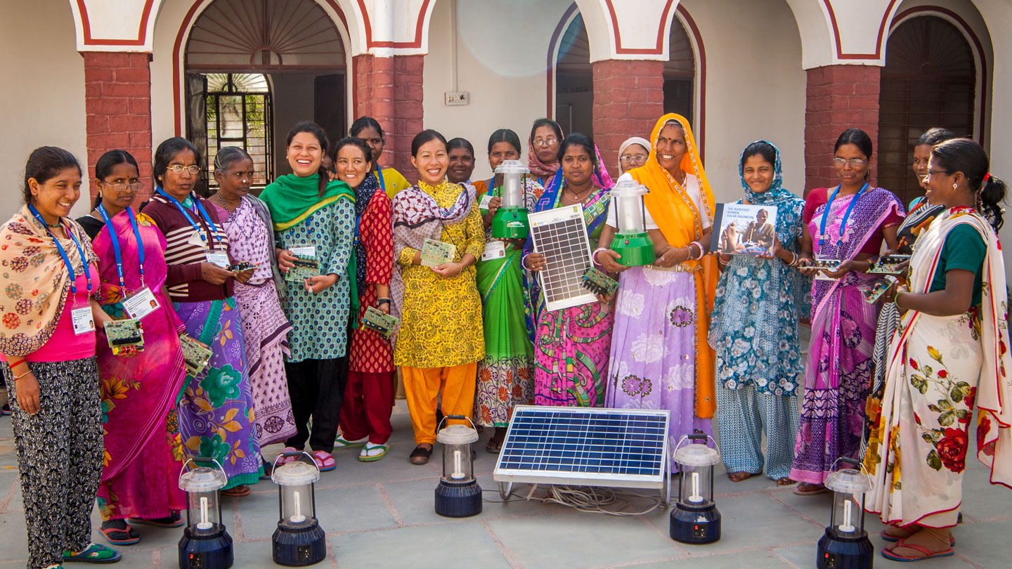 Groupe de femmes affichant des panneaux de cellules solaires, de petits circuits et des lampes électriques