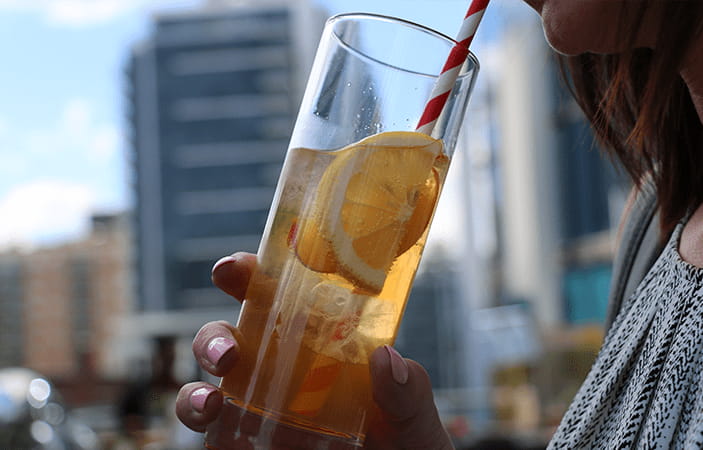 Un gros plan d'une femme buvant une gorgée d'une boisson estivale