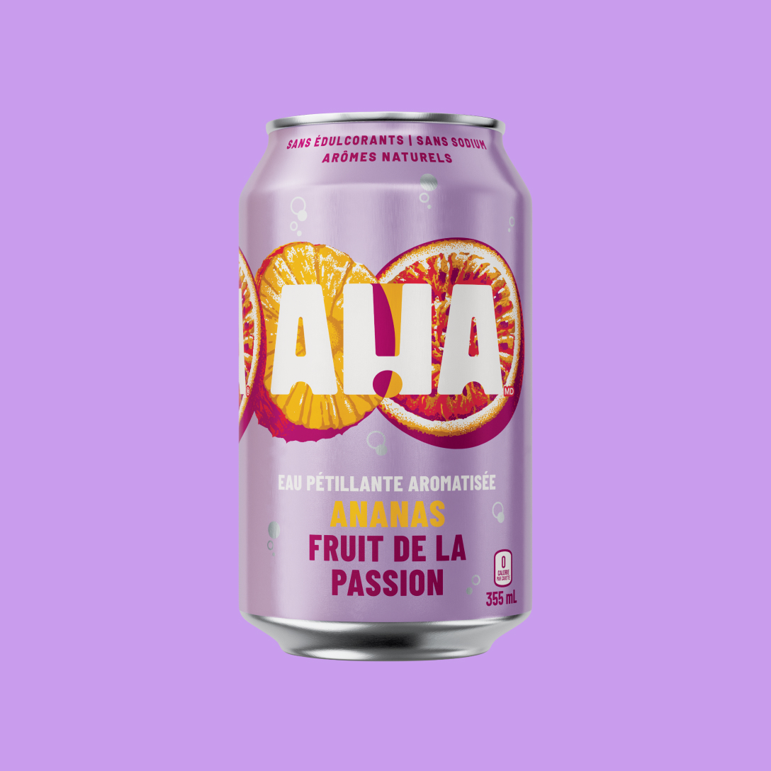 Une canette lavande de 355 mL d'eau pétillante aromatisée AHA ananas et fruit de la passion. Derrière le logo blanc AHA, on voit une tranche d'ananas et un demi-fruit de la passion illustrés. La canette indique « Sans édulcorants | Sans sodium | Arômes naturels » et « 0 calorie par canette ». Elle est présentée sur un fond mauve assorti.
