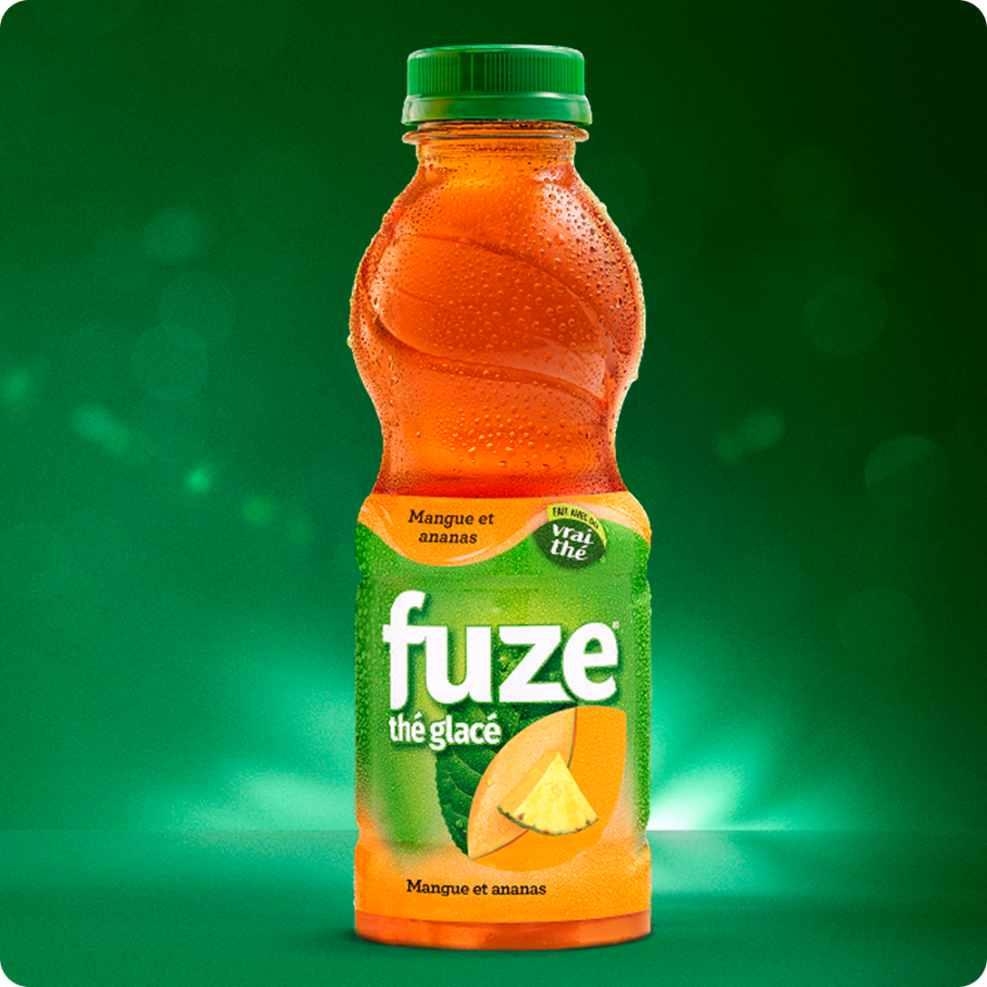 Bouteille fraîche de thé glacé Fuze saveur mangue et ananas sur fond vert éclatant.