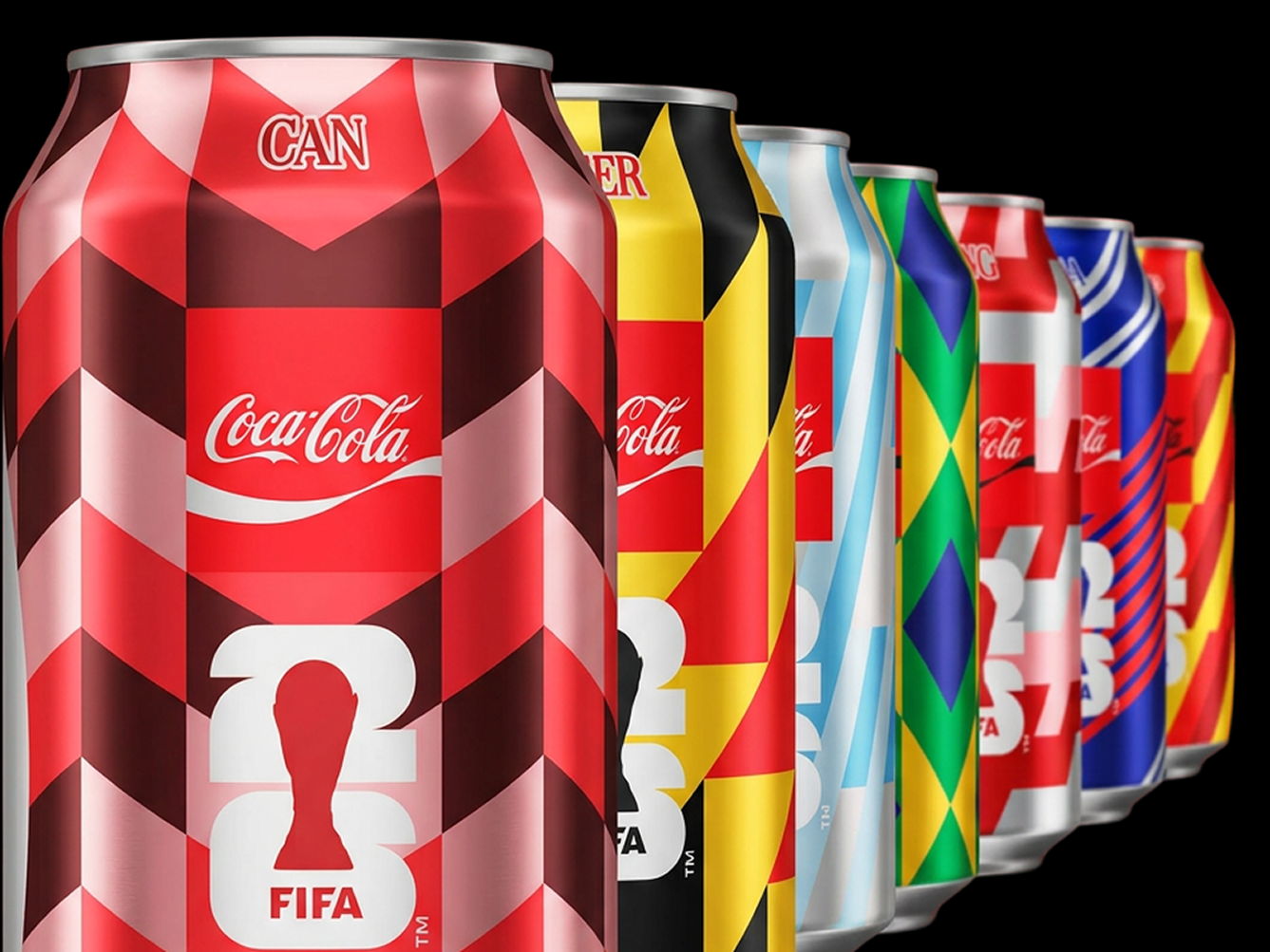 Rangée de canettes Coca‑Cola aux motifs géométriques rouges et multicolores avec une silhouette blanche de trophée sur le devant.