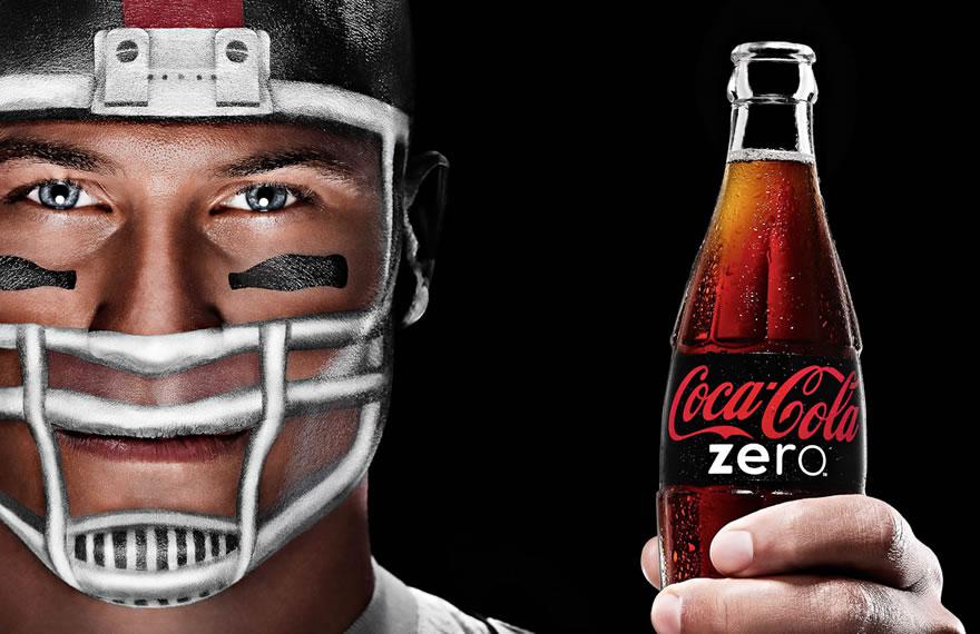 Image of a football player holding a glass bottle of Coca-Cola Zero
