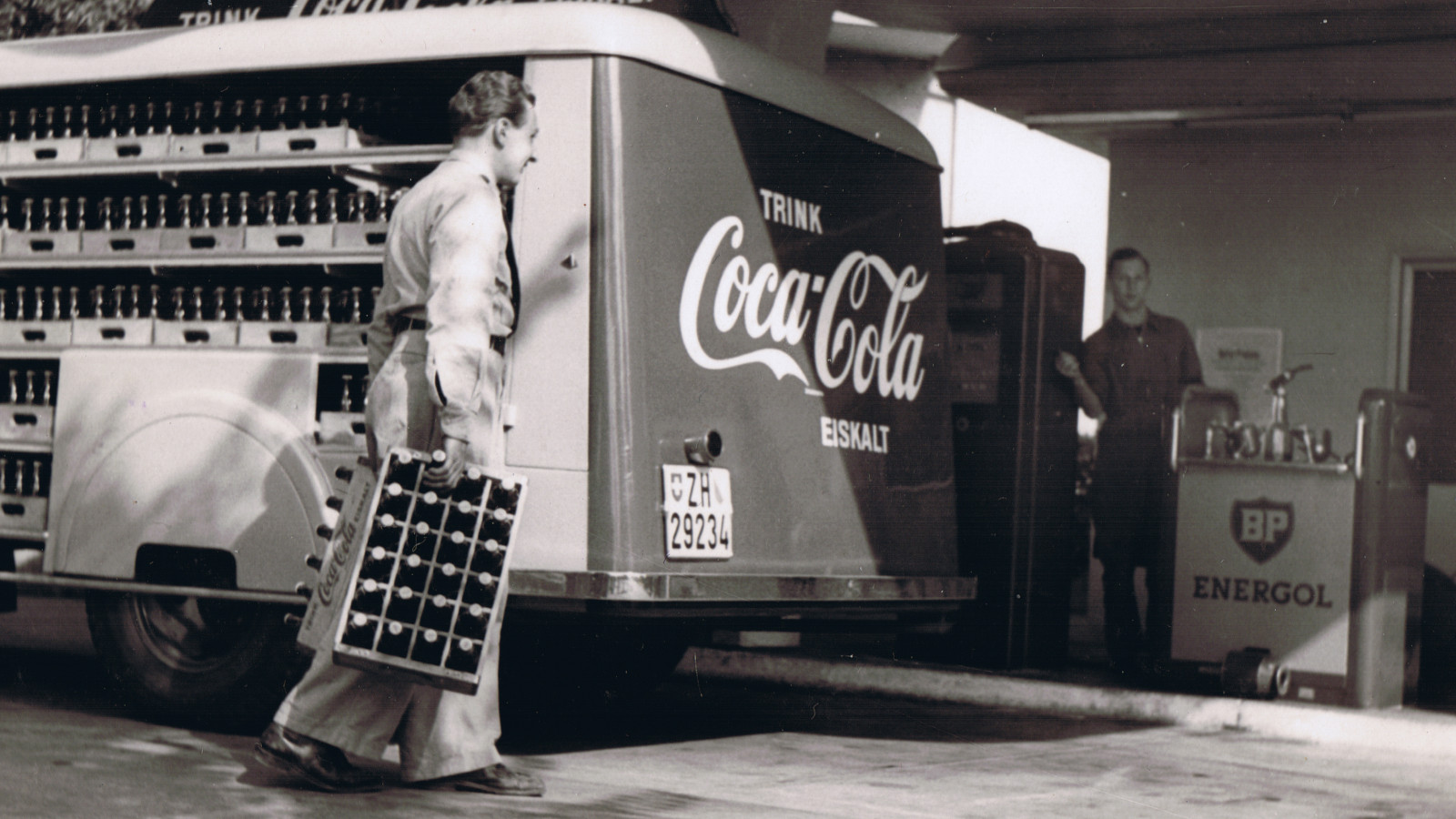 Photo historique d’un véhicule de livraison Coca-Cola devant une station-service en Suisse.