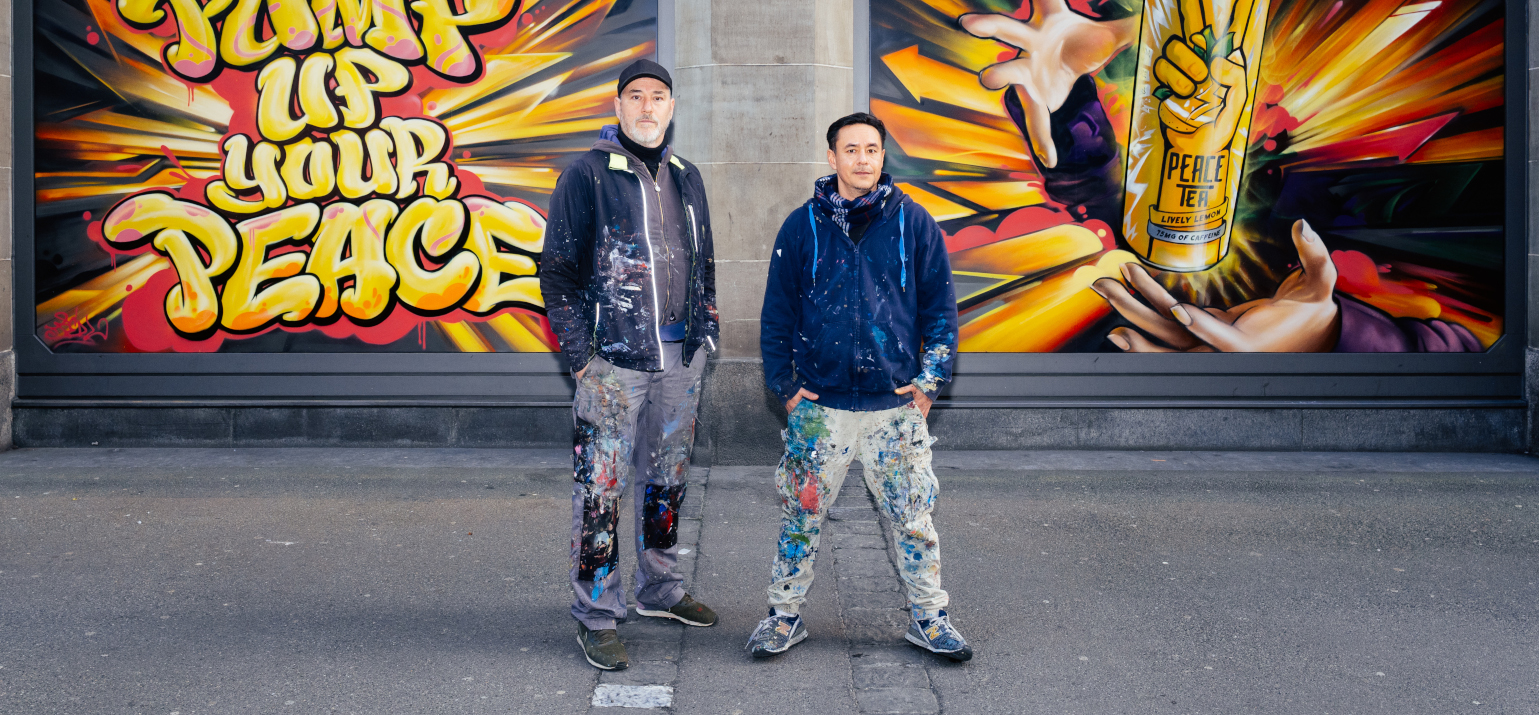 Redl und Alex Hohl vor den bemalten Schaufenstern des Coop St. Annahof