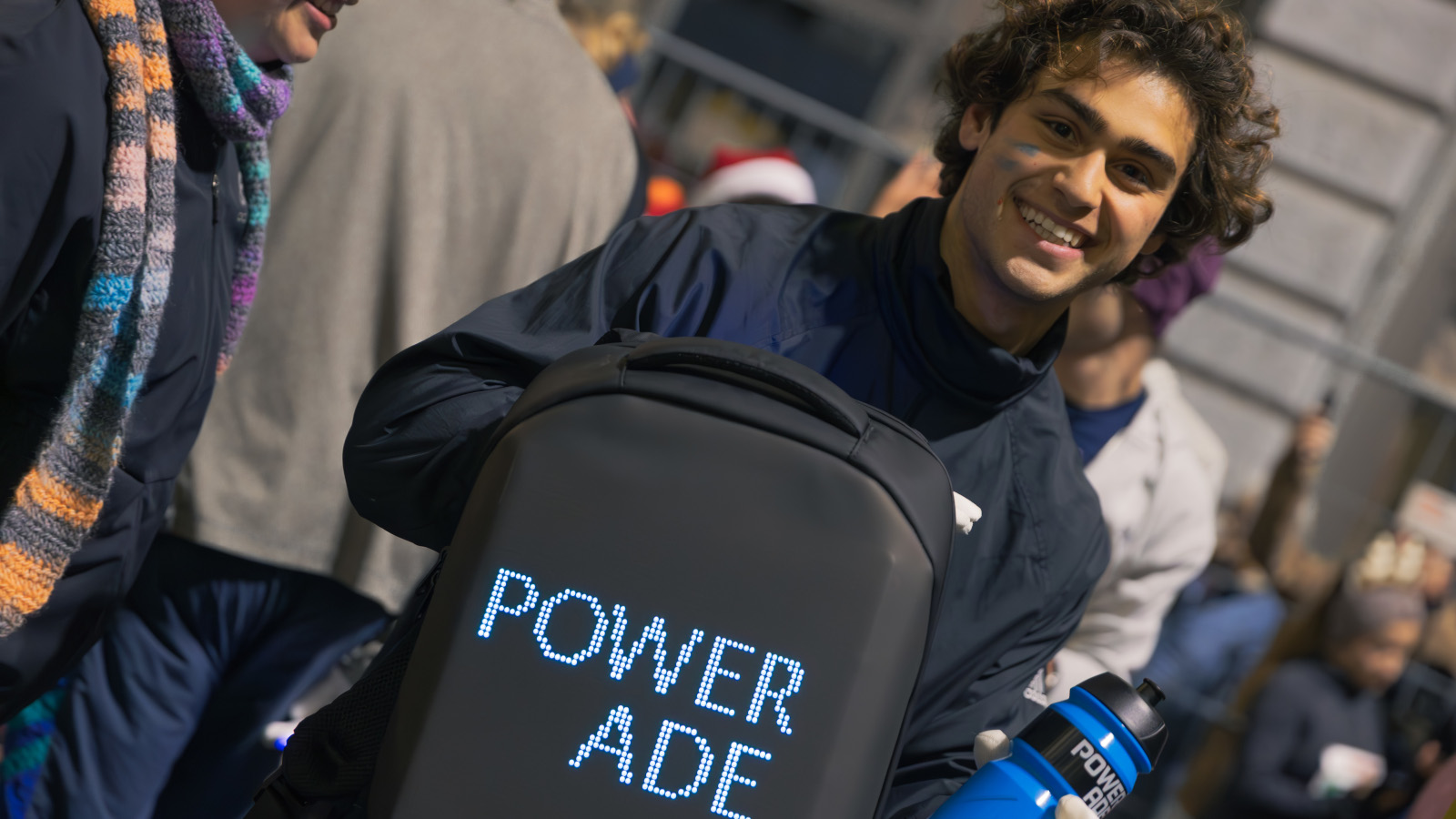 junger Mann mit Powerade Rucksack