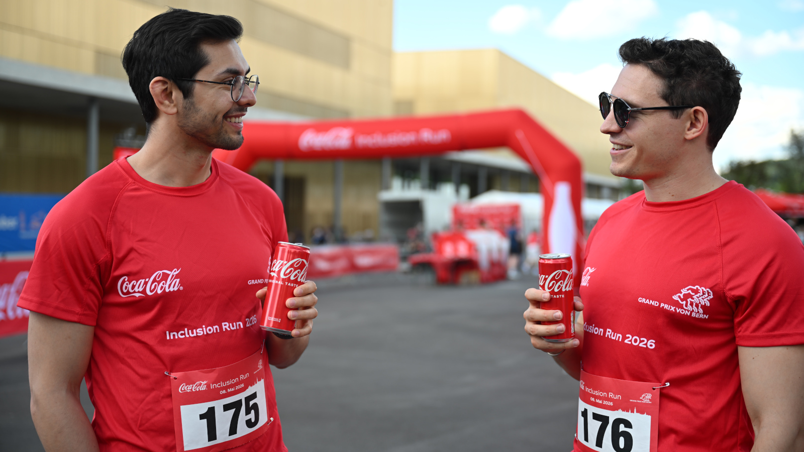 Zwei junge Männer mit einer Coca-Cola in der Hand schauen sich an