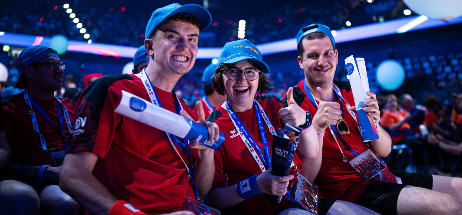 Trois participant-e-s sont assis dans le public lors de la cérémonie d’ouverture des Special Olympics National Games.