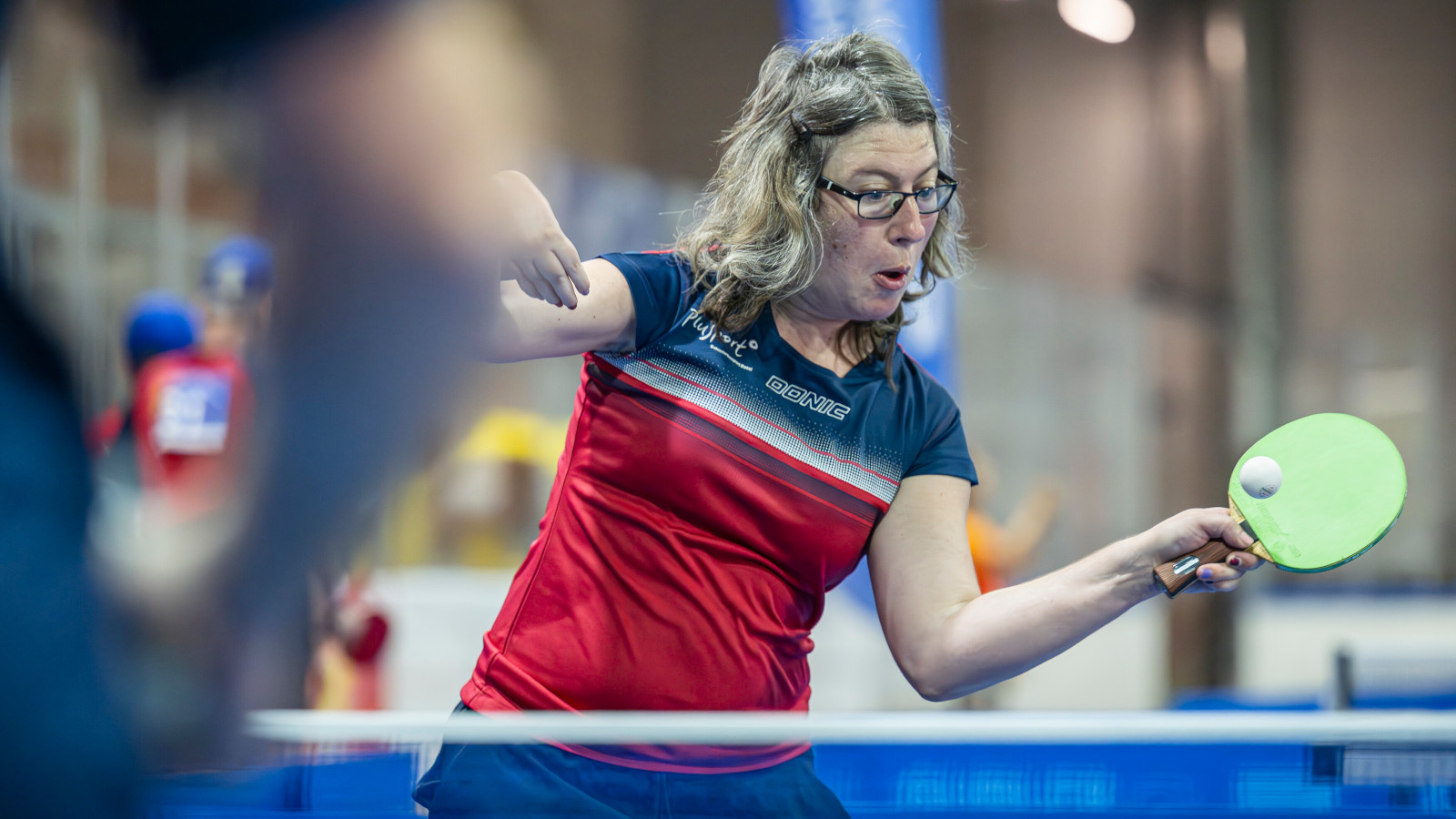 Une athlète joue au tennis de table.