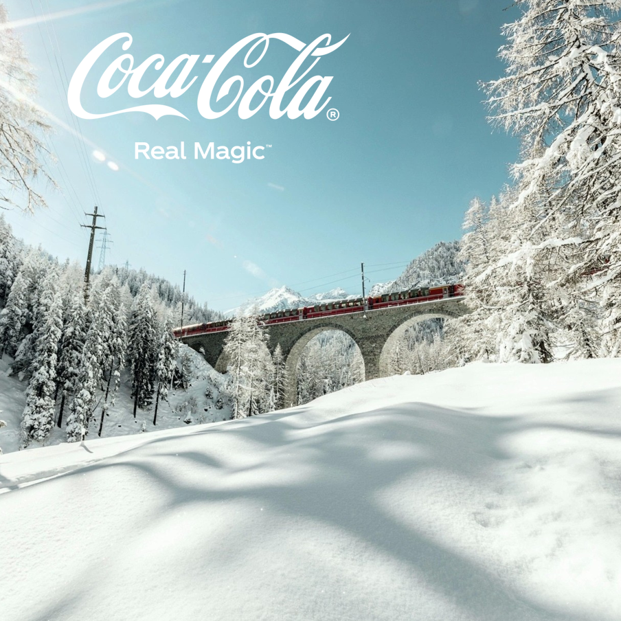 Roter Glacier Express-Zug auf Steinviadukt in verschneiter Alpenlandschaft mit Coca-Cola Logo